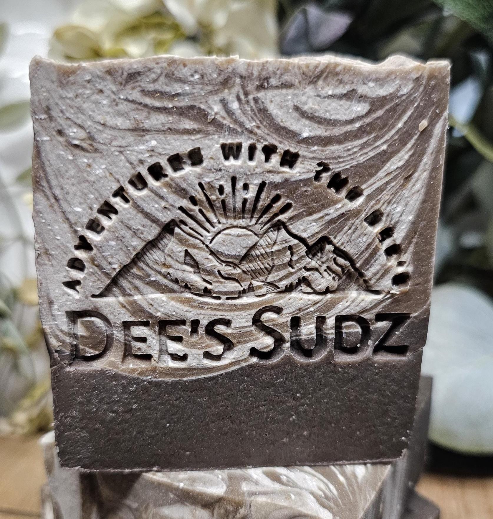 Rectangular handmade soap bar with the Dee’s Sudz logo, featuring a gray and charcoal swirl design with a textured finish.