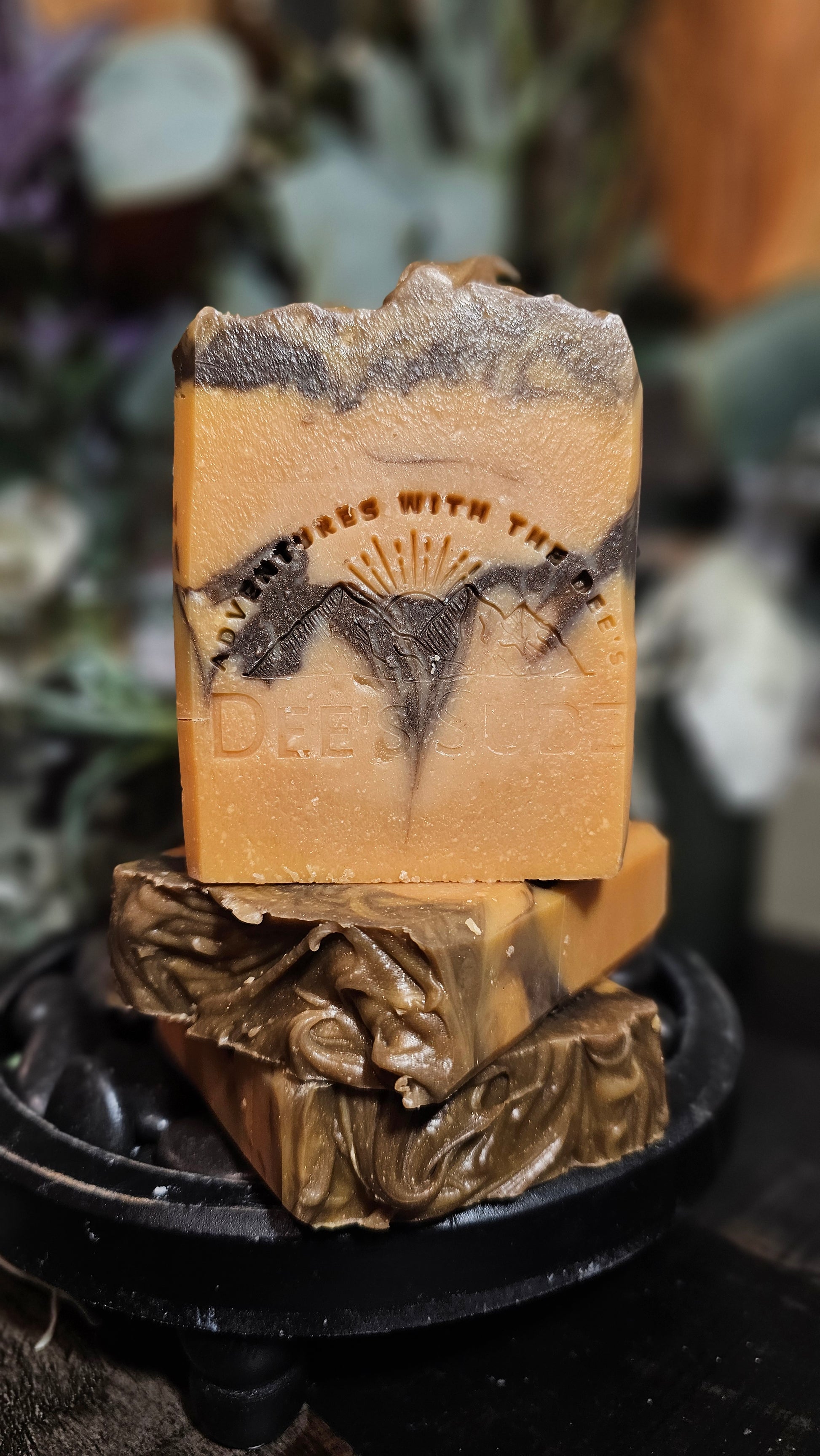 Rectangular handmade soap bar with Dee’s Sudz mountain logo stamp, featuring warm sandstone orange tones with dark brown rock-like layers inspired by desert canyon cliffs.